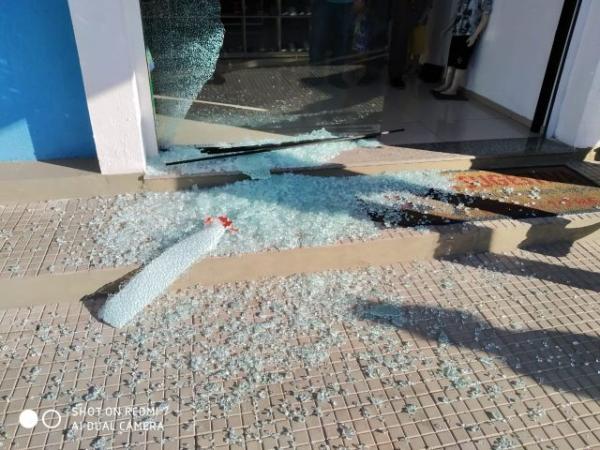 Loja tem a porta de vidro atingida pelos disparos.(Imagem:Divulgação)