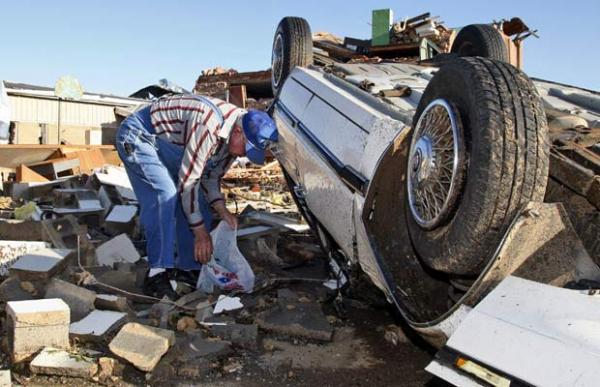 Morador da cidade de Tushka tenta encontrar seus pertences em meio a destruição causada por um tornado(Imagem:AP)