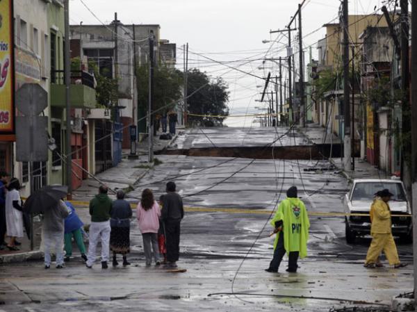 Moradores da Cidade da Guatemala observam neste domingo (30) buraco de rua provocado pelas chuvas trazidas pela tempestade Agatha. (Imagem: (Foto: Reuters))