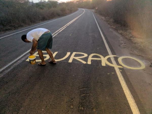Morador pinta PI-141 com avisos para alertar condutores sobre buracos, em Canto do Buriti, Sul do Piauí.(Imagem:Arquivo pessoal/Wilson Ferreira)