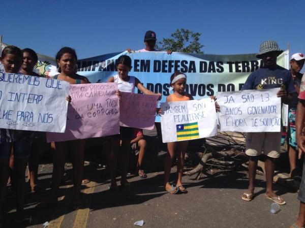 Manifestantes usaram faixas para pedir regularização das terras.(Imagem:Gilcilene Araújo/G1)
