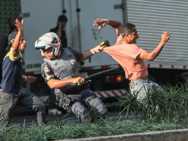 PM tenta deter homem se envolveu em confronto durante reintegração.(Imagem:Marco Ambrosio/Estadão Conteúdo)