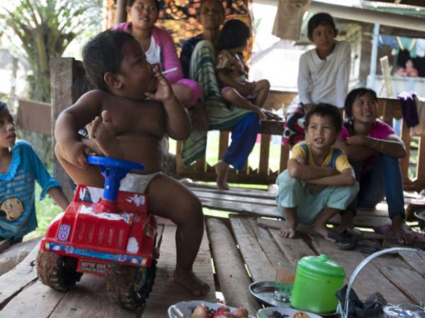 Aldi SugandaRizal, de 2 anos, é visto fumando cigarro enquanto brinca com parentes em 23 de maio, em Sekayu, distrito de Sumatra, na Indonésia (Imagem:Barcroft)