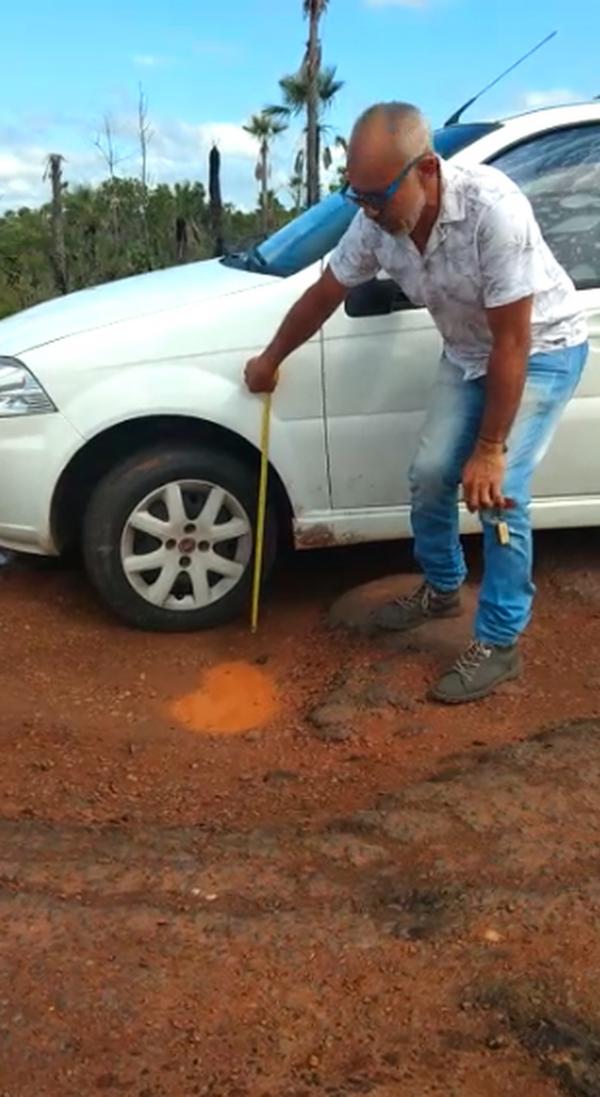 Morador mostra buraco de 30 centímetros de altura na PI-113(Imagem:Reprodução )