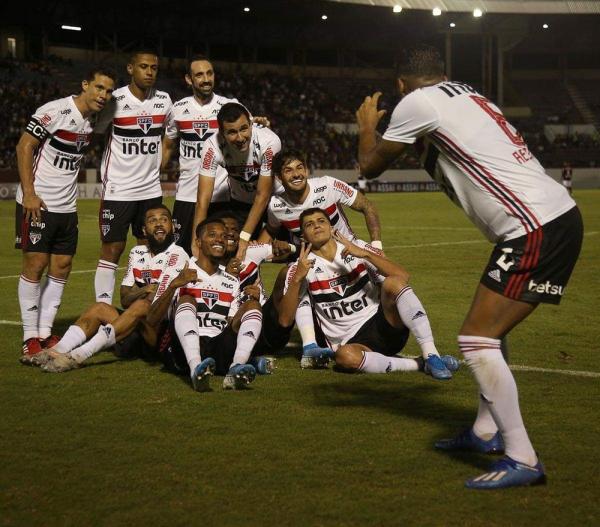 Jogadores do São Paulo comemoram gol com foto de Arboleda com o grupo 