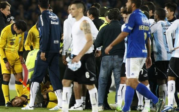 Assistente fica caído no gramado depois da agressão de Elano. (Imagem:AP)