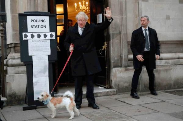 Premiê britânico, Boris Johnson, deixa seção onde votou em Londres nesta quinta-feira (12) com o seu cachorro, Dylan(Imagem:Frank Augstein/AP)