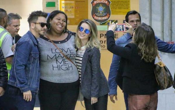 Sandy e Junior atendem fãs após desembarcarem em aeroporto do Rio.(Imagem:Divulgação)