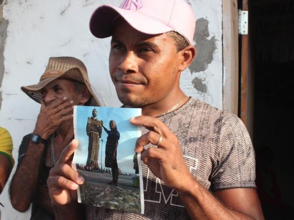 Pedro Vinícius segura a foto da avó, uma das vítimas da chacina.(Imagem:Catarina Costa)