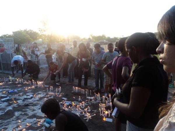 Pessoas acendendo velas no cruzeiro - Cemitério Central de Floriano(Imagem:Cida Santana)