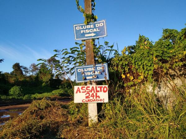 Morador fixa placa de alerta sobre assaltos no bairro Porto do Centro, Zona Leste de Teresina.(Imagem:Rafaela Leal /G1 PI)