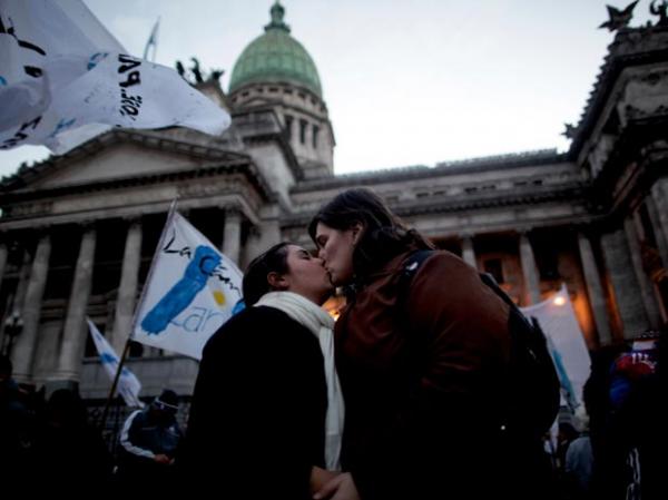 Casal gay beija-se nesta quarta-feira (14) em frente ao Congresso em Buenos Aires, na Argentina. (Imagem:AP)