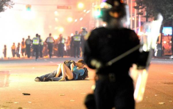 Scott Jones e Alexandra Thomas se beijam no asfalto durante tumulto, na foto que teve repercussão em todo o mundo.(Imagem:Rich Lam/Getty Image)
