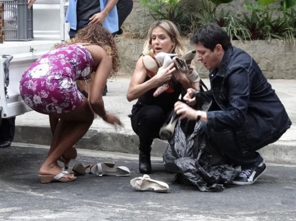 Natalie tenta recuperar os sapatos espalhados pela rua.(Imagem:Insensato Coração / TV Globo)