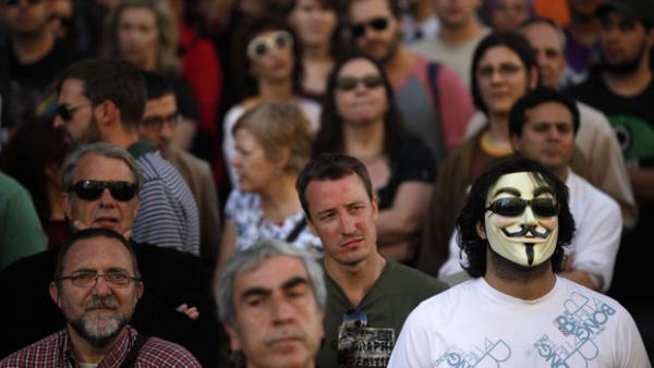 Durante o movimento ?Democracia Real Agora?, em Madri (Espanha), uma pessoa é vista com uma máscara de Guy Fawkes, de 'V de Vingaça' usada por membros do grupo de hackers Anonymous(Imagem:Susana Vera/Reuters)