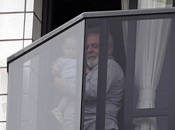 Lula com uma criança na sacada do apartamento onde mora, em São Bernardo.(Imagem:Marcos Alves / Agência O Globo)