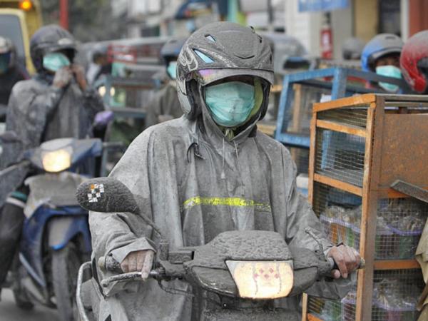 Verdureiros usam máscaras e roupa especial durante trabalho de entrega de alimentos a afetados pela erupção do vulcão na cidade de Magelang, nesta sexta (5) ? Foto:(Imagem:Beawiharta/Reuters)