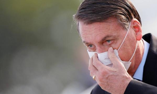 Presidente Jair Bolsonaro ajeita máscara durante evento no Palácio da Alvorada, em Brasília.(Imagem:ADRIANO MACHADO / REUTERS)