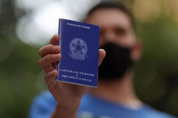 Homem segura carteira de trabalho enquanto procura emprego na região central de São Paulo.(Imagem:Amanda Perobelli/Reuters)