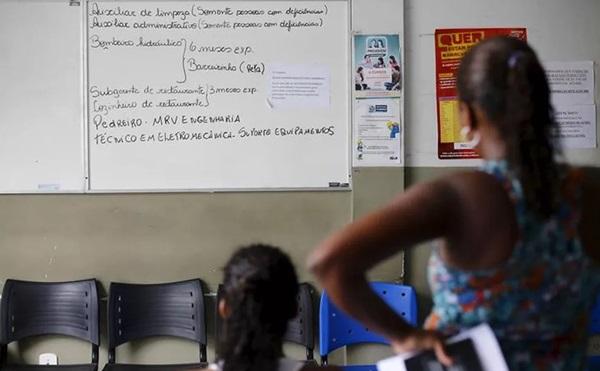 Mulheres sem emprego observam quadro com vagas de trabalho(Imagem:Ricardo Moraes/Reuters)
