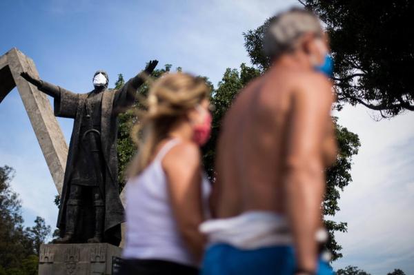 Moradores caminham em frente ao monumento à Pedro Álvares Cabral, no Ibirapuera, zona sul de São Paulo, para praticar exercícios físicos nesta terça, 12.(Imagem:FELIPE RAU/ESTADÃO)