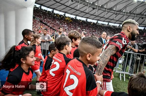  Com a pequena Alice e outras sorridentes crianças, Gabigol entra em campo para jogar partida que encaminhou o hepta do Flamengo.(Imagem:Nayra Halm/Foto do Jogo )