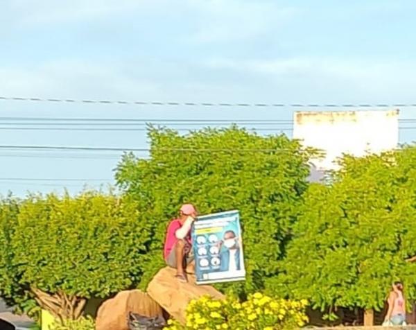 Homem segura cartaz após acordo com a Justiça para não pagar multa em Simplício Mendes.(Imagem:Divulgação)