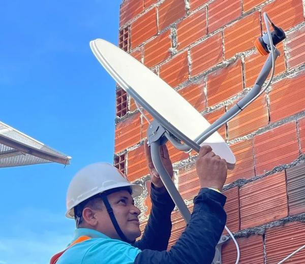 Técnico instala nova antena parabólica digital em casa.(Imagem:Divulgação)