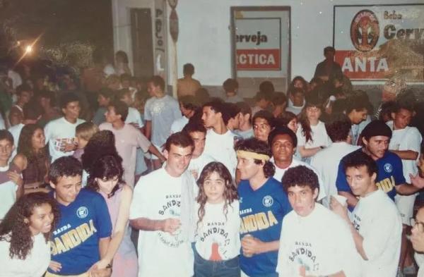  Bloco Banda Bandida em Teresina na década de 80, no centro da imagem, abraçados na mulher estão o repórter Tino Marcos de camisa branca e Último Coelho, de camisa azul e faixa ama(Imagem: Arquivo Pessoal / Antônio Fernandes )