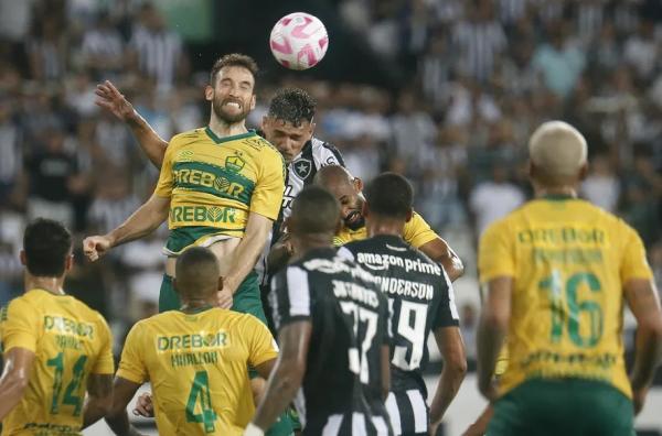 Tiquinho disputa bola pelo alto com Empereur.(Imagem:Vitor Silva/Botafogo)