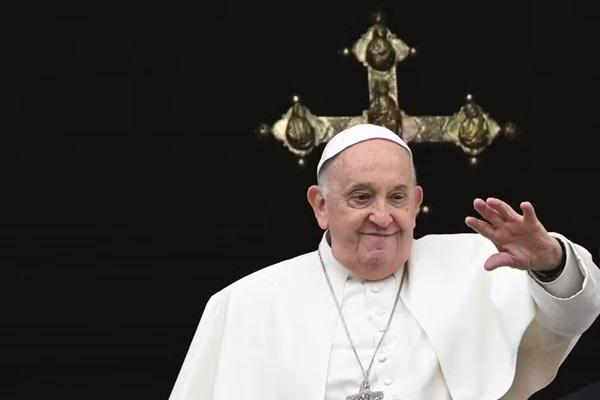 O Papa Francisco acena da galeria central da Basílica de São Pedro durante a mensagem pascal, como parte das celebrações da Semana Santa, no Vaticano (Imagem: TIZIANA FABI / AFP)