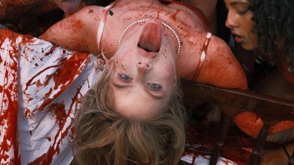 Em novo clipe, Luísa aparece em uma cama com manchas vermelhas fazendo alusão ao sangue e ao líquido que solta do morango.(Imagem:Divulgação)