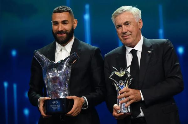 Ao lado de Karim Benzema, Ancelotti exibe seu troféu de melhor técnico da temporada, dado pela Fifa.(Imagem:Ozan Kose/AFP)