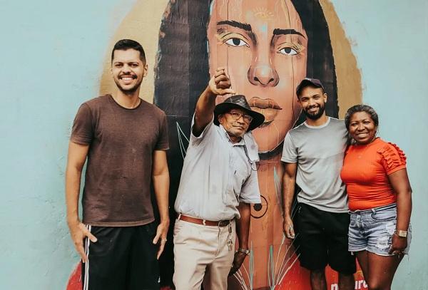  Antônio Filho (o primeiro da esquerda para a direita) idealizador do projeto Afrofuturismo ao lado de algumas pessoas em frente ao mural de Francisca Trindade em Teresina.(Imagem:Reprodução )