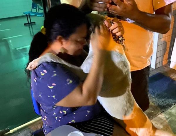 Cachorro abraça mulher que perdeu mãe vítima da Covid-19, em Teresina.(Imagem: Arquivo Pessoal Rhavenna Veloso)