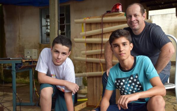 Em um laboratório improvisado dentro da garagem de casa, o professor de ciências Carlos Renato da Silva, de Batatais (SP), ensina o filho e as crianças da vizinhança a construírem(Imagem:Reprodução)