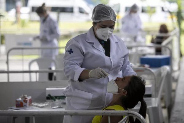 Profissional de saúde coleta amostra nasal para teste de Covid-19 em uma escola no Rio de Janeiro, no Brasil, em 7 de janeiro de 2022.(Imagem:Bruna Prado/AP)