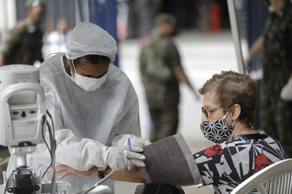 Uma profissional de saúde mede a pressão arterial de uma mulher com suspeita de Covid-19 na Unidade de Pronto Atendimento (UPA) Marechal Hermes, no Rio de Janeiro, em 6 de maio.(Imagem:Silvia Izquierdo/AP/Arquivo)